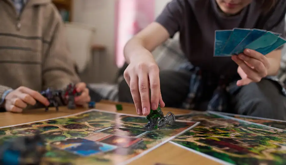 Speler plaatst een miniatuurfiguurtje op een gedetailleerde fantasierijke strategische bordspelkaart.