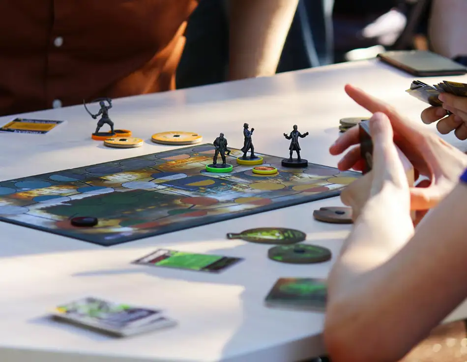 Groep spelers die miniaturen en fiches verplaatsen op een strategisch bordspel tijdens een spelsessie.